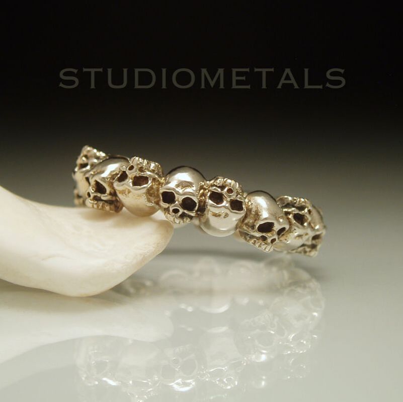 delicate white gold skull eternity band