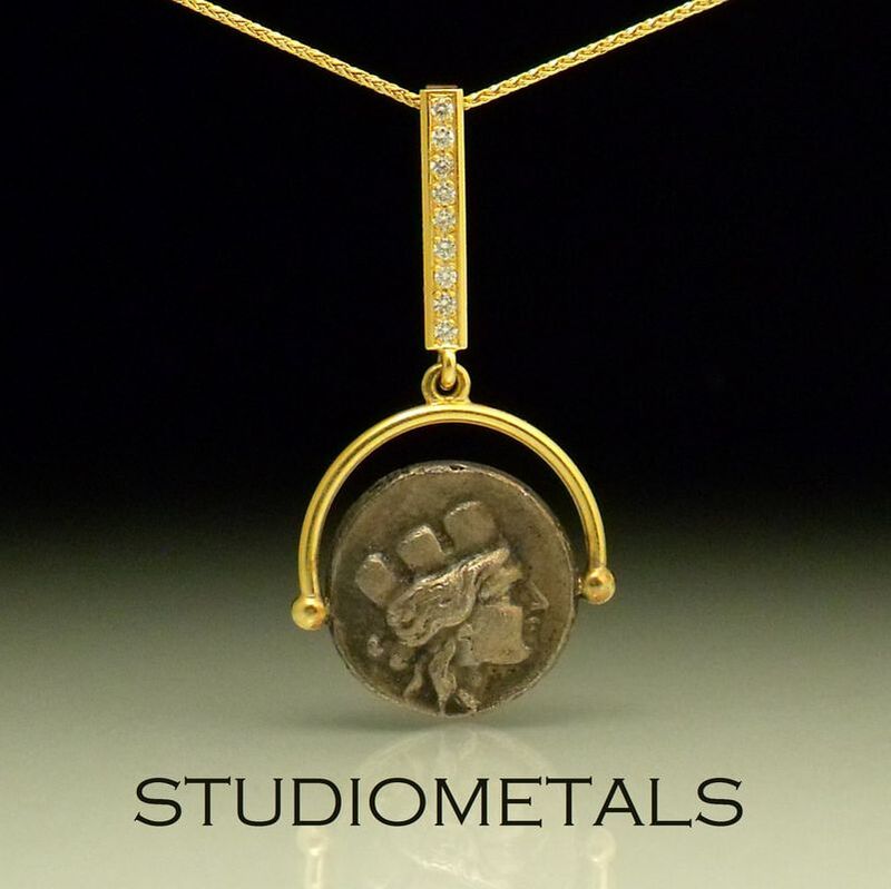 18k yellow gold pendant with pave set diamonds and a sterling silver reproduction Roman coin.