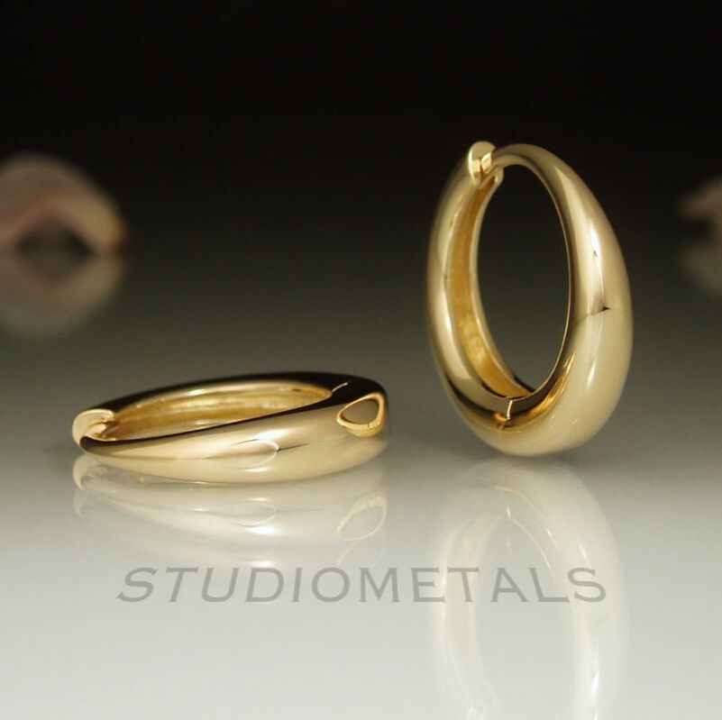 18mm rounded, tapered hoop earrings with hinges in solid, 14 karat yellow gold.