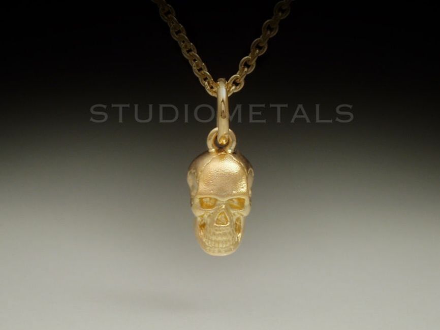 Matte 18 karat yellow gold human skull charm, 14mm total length.