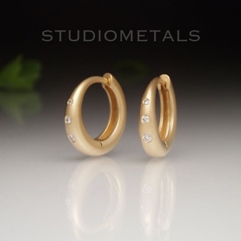 Matte 18 karat yellow gold 14mm hinged hoops with natural, vs clarity flush set diamonds.