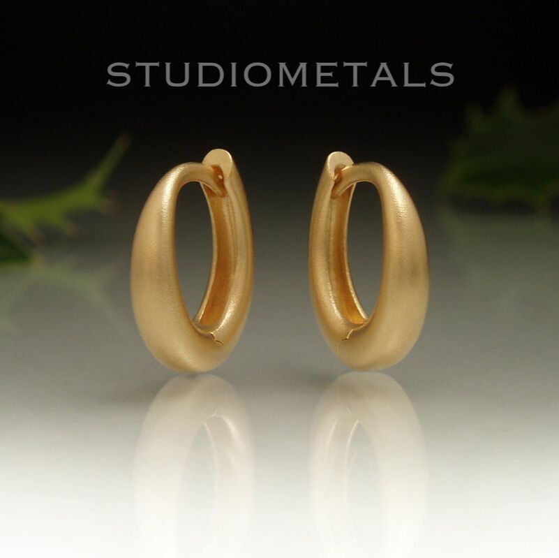 Solid, matte 18kt yellow gold, 13mm oval huggie hoop earrings. 