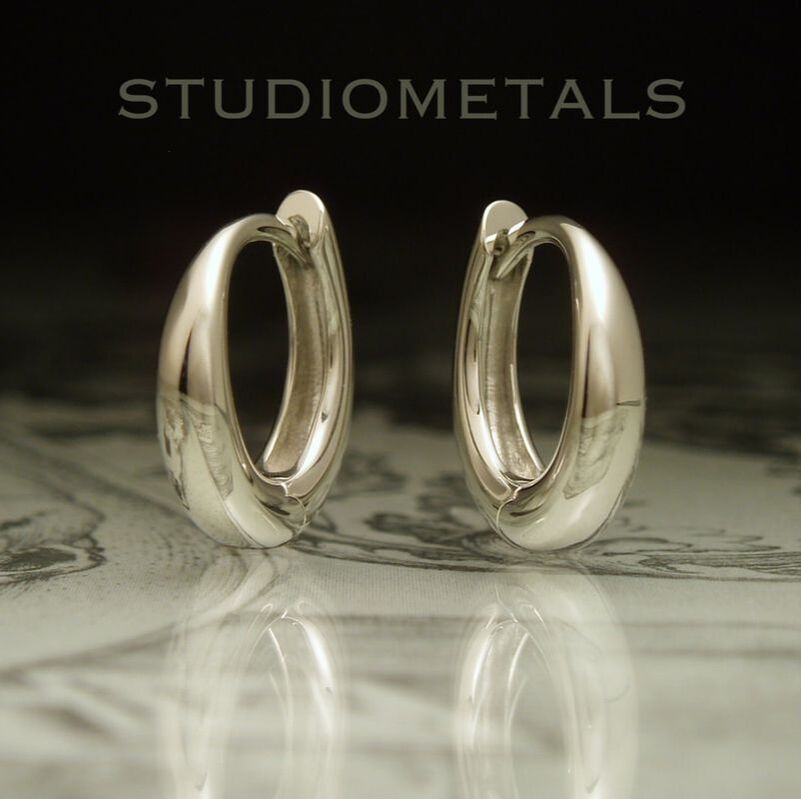 Solid, unplated 18k white god 13mm tapered oval huggie hoop earrings.