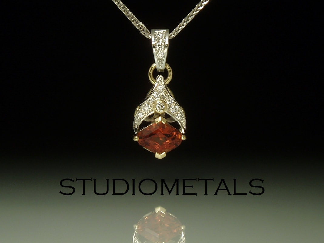 Red garnet and pave diamond pendant in 19k white and 18k yellow gold