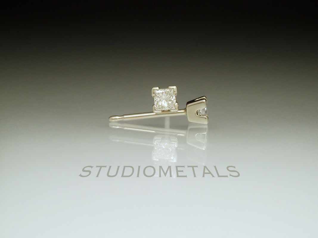 Tiny princess cut diamond stud earrings in 14k white gold fishtail settings.