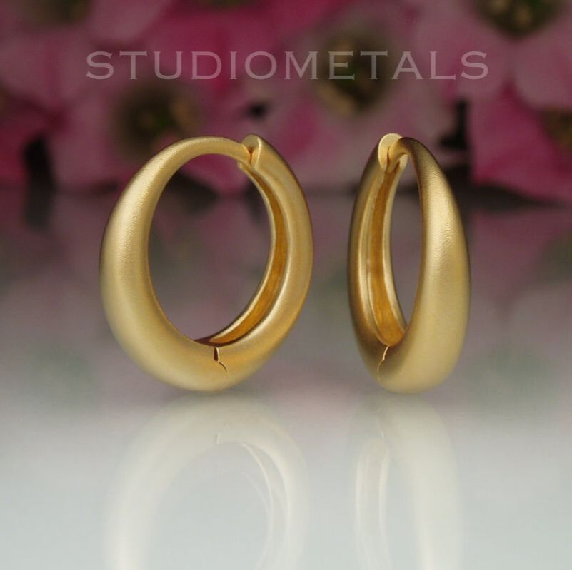 Solid, matte 18K gold, 18mm tapered hoop earrings.