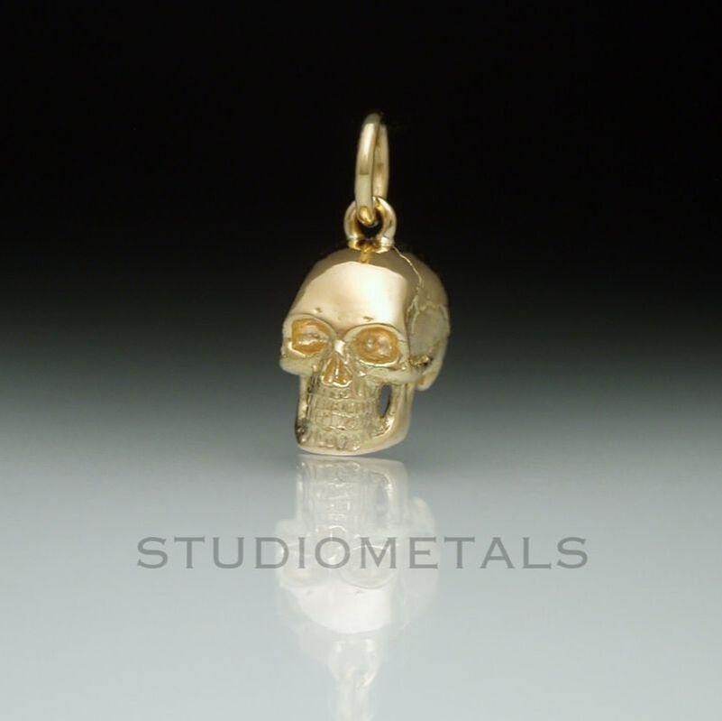 Hand carved, 10mm skull pendant in 14k gold. Total pendant length of 16mm.