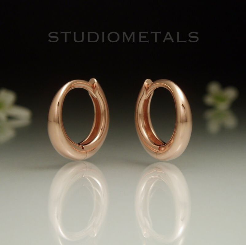 Round 12mm, hinged sleeper huggie hoops in solid 14k rose gold.