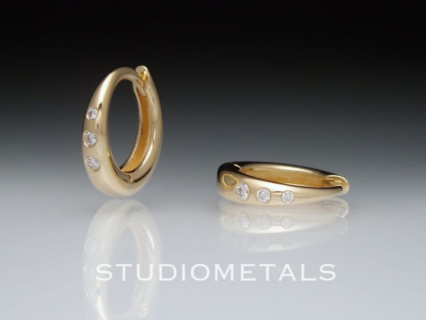 18 karat yellow gold, 12mm round huggie hoop earrings with natural, VS clarity, flush set diamonds.