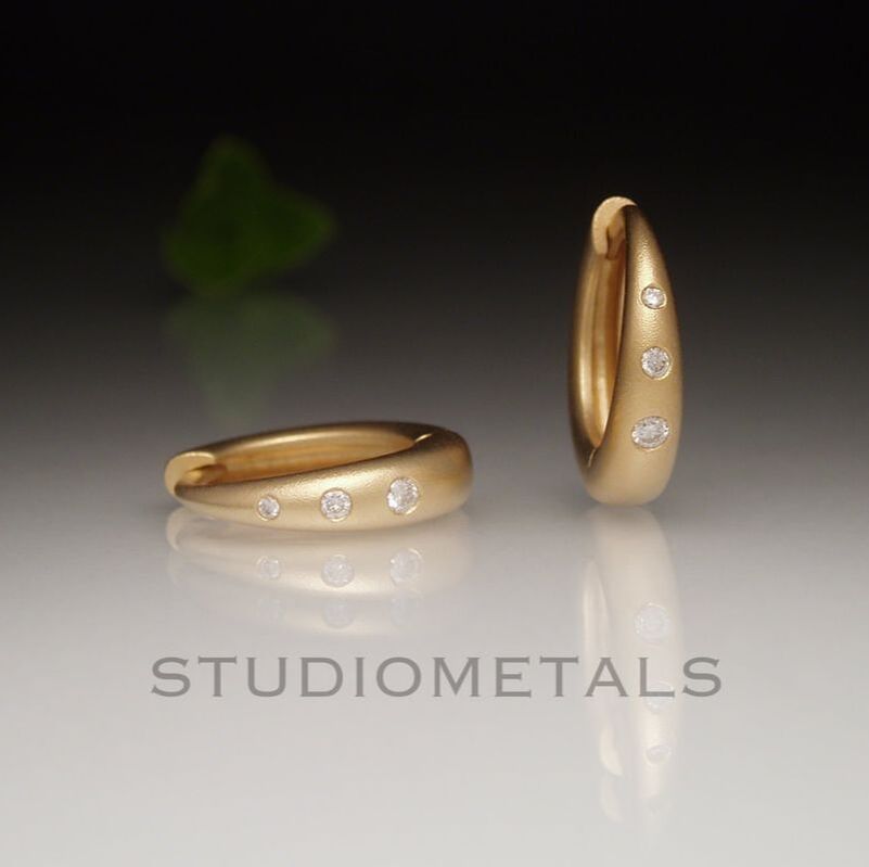 14mm round hoop earrings with flush set diamonds in 18k yellow gold.