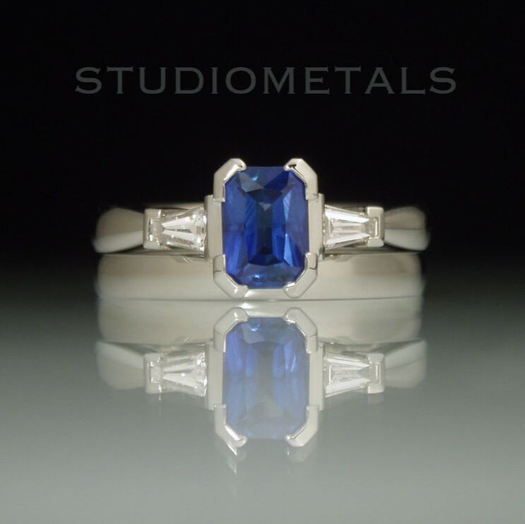 Radiant cut, fine blue sapphire engagement ring with tapered diamond baguettes and matching wedding band.