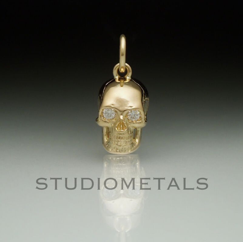 16mm skull pendant in 14 karat with vs diamond eyes.