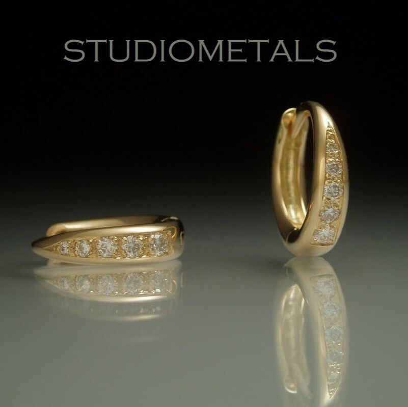 14k polished yellow gold, 11mm oval huggie earrrings bead set with diamonds.