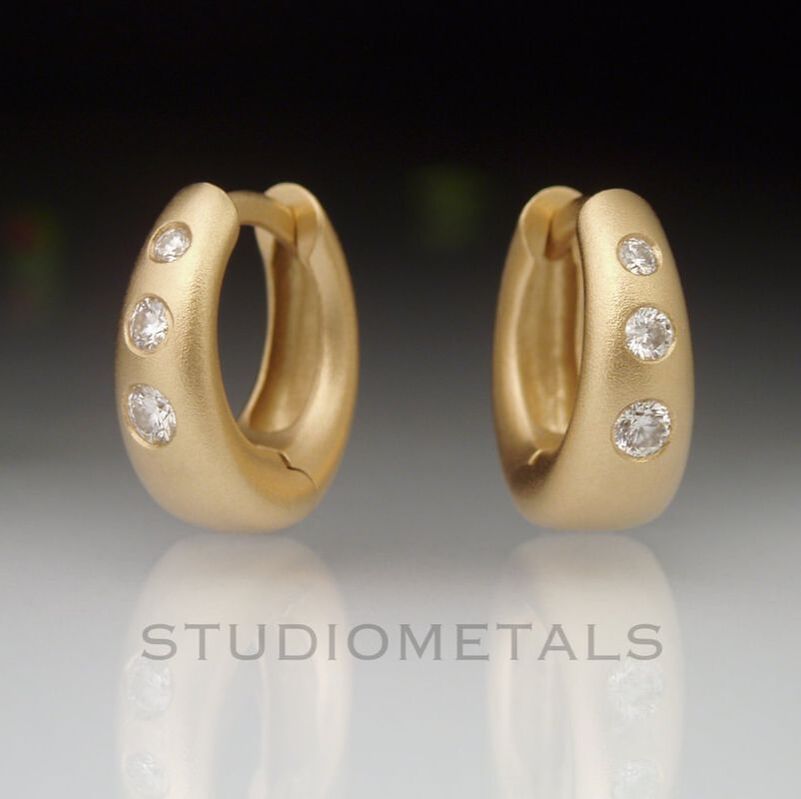 Matte, 18 karat yellow gold, wide tapered huggie hoops with flush set, earth mined diamonds.