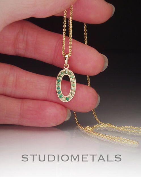 Custom made, solid 14k yellow gold oval pendant necklace pave set by hand with genuine emeralds, tsavorite garnets and peridots.