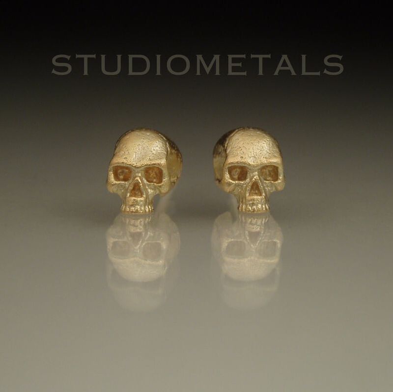 Jawless, half skull stud earrings in solid 14 karat yellow gold.