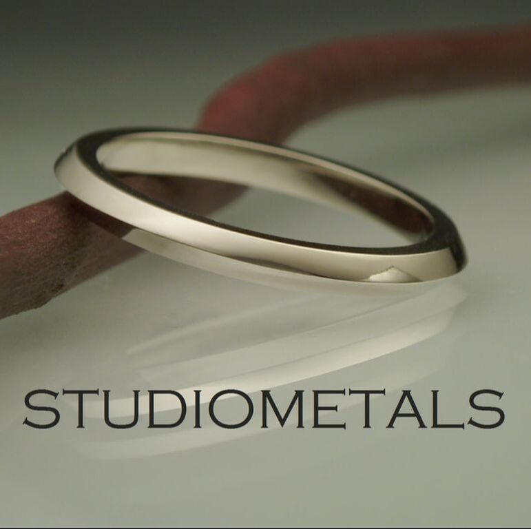 Narrow, knifed edge band ring in 14 karat white gold.