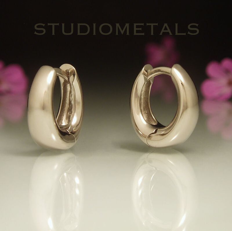Wide tapered oval huggies in nickel free, hypoallergenic white gold.