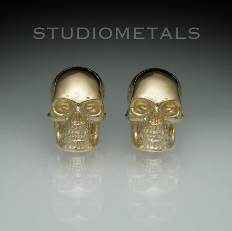 10mm skull stud earrings in polished 14 karat yellow gold.