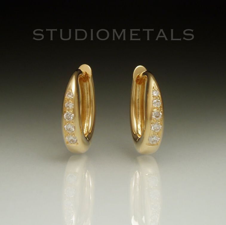 13mm oval huggie earrings in solid, 18 karat yellow gold with pave set natural, earth mined vs clarity diamonds.