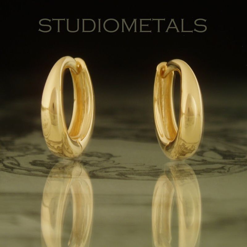 13mm oval hinged huggie hoop earrings in solid 18 karat yellow gold.