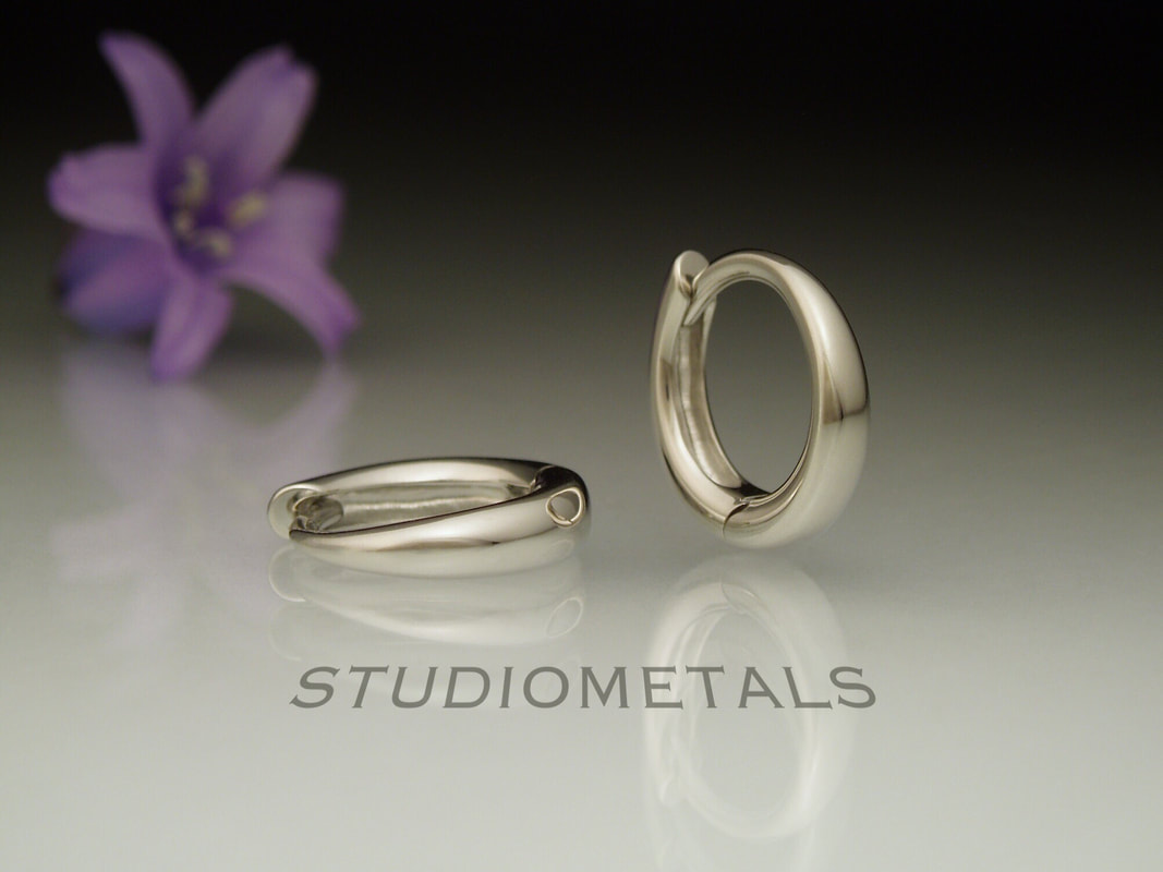 tiny oval hinged huggies in solid white gold