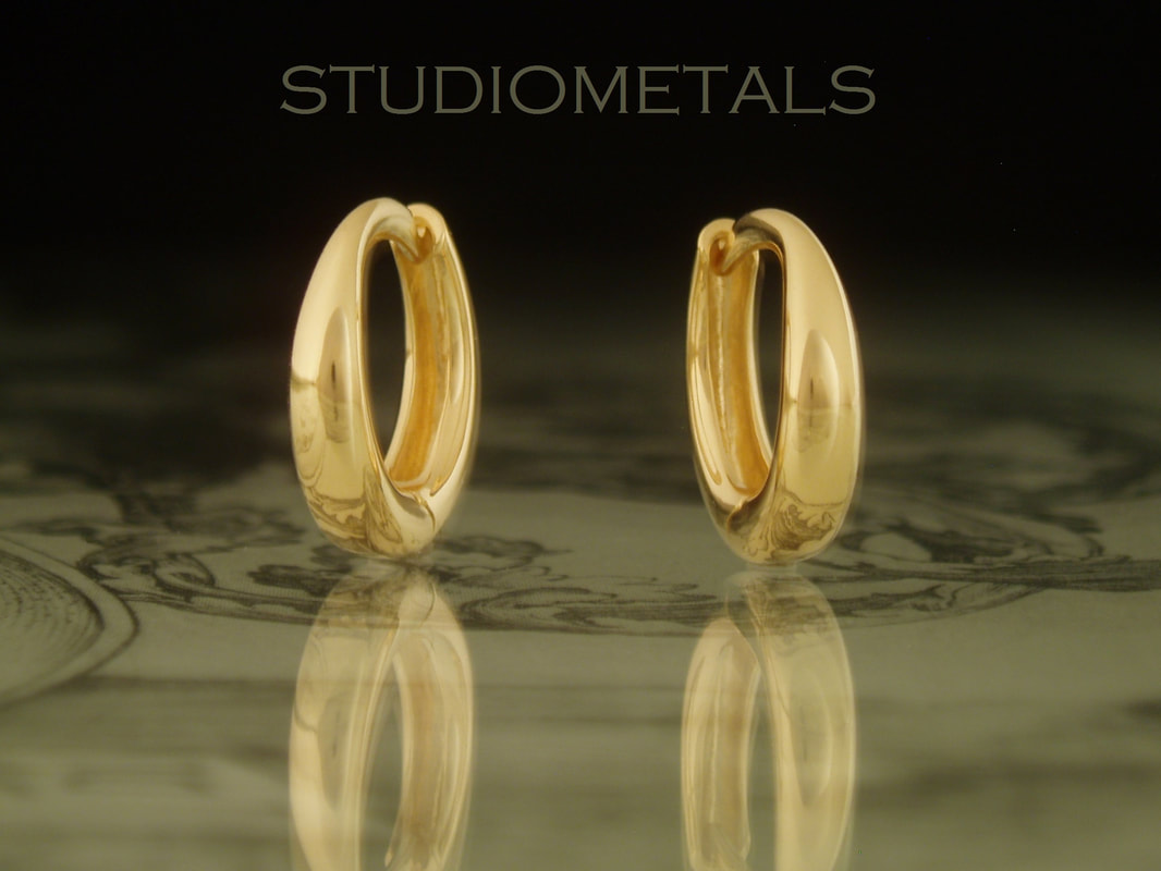 13mm oval hinged huggie hoop earrings in solid 18 karat yellow gold.