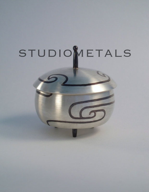 Sterling sikver vessel with shakudo inlay and 14K interior details.