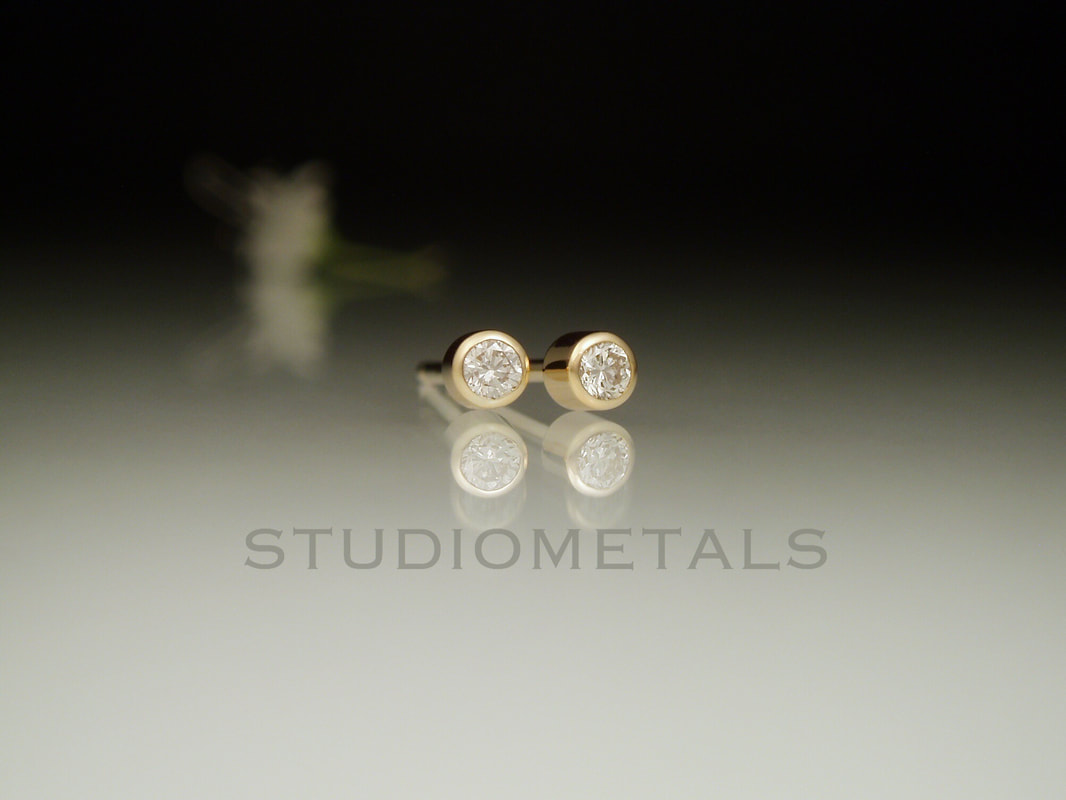 2mm diamond bezel set stud earrings in 14k yellow gold.